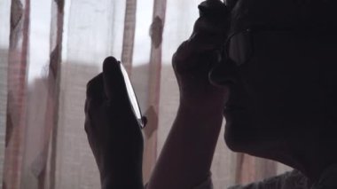 Kaşlarını cımbız ve aynanın yardımıyla şekillendiren yaşlı kadın - Covid Karantina