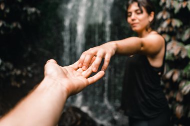 Genç beyaz erkek ve kız kollarını uzatıyorlar ve şelalenin kenarında el ele tutuşuyorlar Walt Wheta tramvayı, Yeni Zelanda - yaşam tarzı konsepti