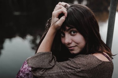 Genç bir kadın kollarıyla kameraya bakıyor - yaşam tarzı konsepti