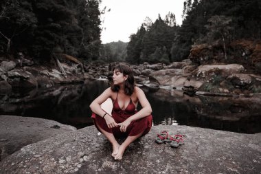 Çocuk kayanın üzerinde oturmuş düşünüyor - yaşam tarzı konsepti