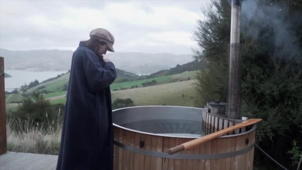 バスローブの白人女性は 屋外で熱い風呂を取るためにそれを取る 新しいニュージーランド ライフスタイルの概念 — ストック動画
