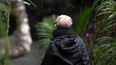 Yeşil ormanın ortasında yürüyen bir kadın, Yeni Zelanda - seyahat yaşam tarzı konsepti