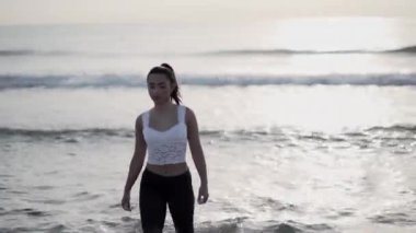 Doğu İspanya 'da sahilde yürüyen esmer kadın ruhani öğretmen.