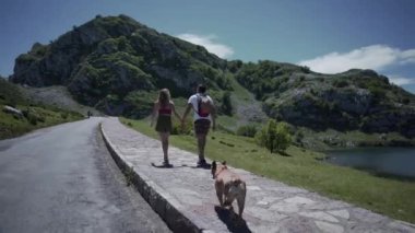 İspanyol çift Asturias İspanya 'da bir köpekle gölün yanında yürüyor - 4K Yatay Seyahat videosu