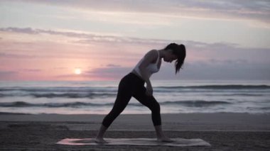 Valencia 'da deniz kenarında yoga yapan kadın ruhani öğretmen.