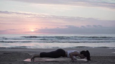 Plajda, at kuyruklu İspanyol bir kız bacaklarını mindere uzatıyor.