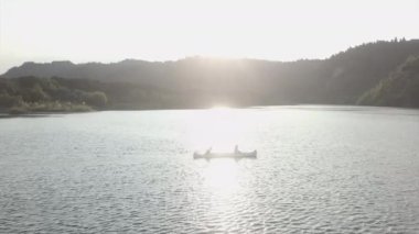 Uçsuz bucaksız deniz manzarası, teknede bir çift ve güneşe karşı, Yeni Zelanda - seyahat kavramı