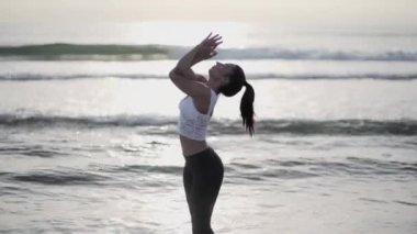 Kafası ve elleri havada bir spor kıyafetiyle suda gezen ruhani bir öğretmen.