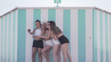 Bir grup kız İspanyol sahilinde gülerken selfie çekiyor - yaşam tarzı konsepti