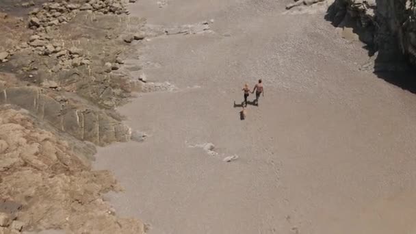 Para Pecinta Berjalan Pantai Batu Dengan Seekor Anjing Mengelilingi Gunung — Stok Video