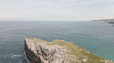 Güneşli bir günde bir uçurumun dönüşlü görüntüsü ve deniz dalgaları - doğa videoları