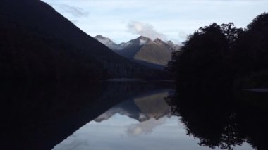 Dağların güzel manzarası ve gün batımında kristal berrak göl, Yeni Zelanda - doğa konsepti