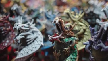 Tayland 'daki bir markette ejderha heykelciği tutuyor ve tütsü yakıyor.