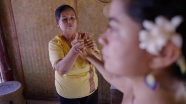 Taylandlı yaşlı masöz İspanyol kadına el masajı yapıyor - yan görüş - Tayland geleneği