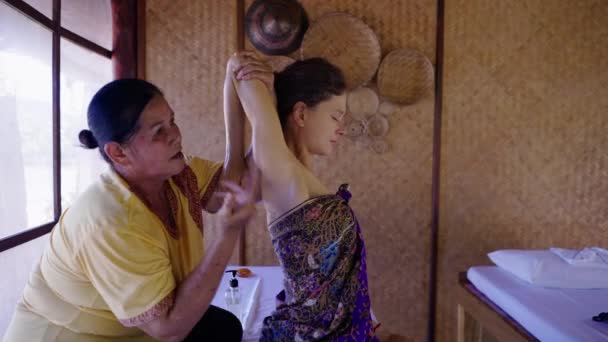 オイルマッサージを受けたウェルネスセンターでの女性のサイドビュー タイの伝統 — ストック動画