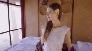 Mutlu kadın kameraya bakar ve lüks sağlık merkezinde masaj masalarının yanında dururken gülümser.