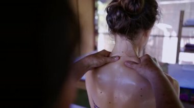 Tanınmayan masaj terapisti yağ ile sırt ve omuz masajı yapıyor - Tayland geleneği