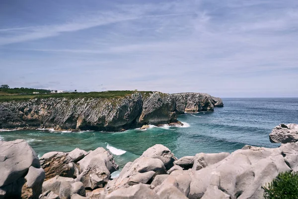 stock image cliffs of the coast with grass next to the stones and rocks under a blue sky a calm day, ribadesella asturias, spain - North of Spain