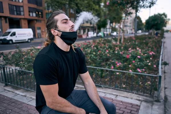 Young Caucasian Man Black Shirt Sitting Vaping Exhaling Water Vapor — Stock Photo, Image