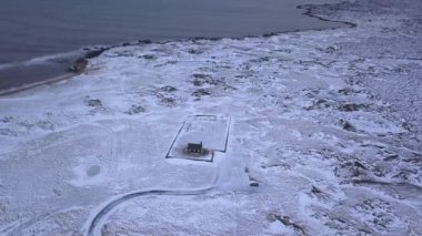 Gökyüzünden görüldüğü gibi deniz kenarındaki kardaki kilise - seyahat konsepti