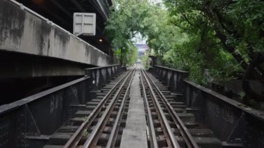 Bangkok Bangkok Caddesi 'ndeki ağaçlarla çevrili demiryolu hattı.