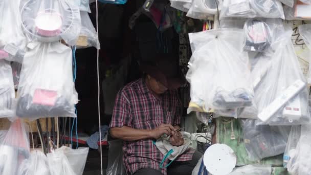 Asian Man Hat Glasses Playing Mobile Phone His Market Stall — Stock Video
