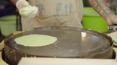 Bangkok Bangkok Caddesi 'ndeki bir markette spatulayla krep pişiren eller.