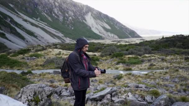 Hombre Fotógrafo Filmando Con Mochila Chaqueta Monte Cocinero Nueva Zelanda — Vídeos de Stock