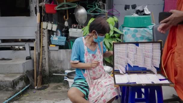バンコクで宝くじを販売しているマスクのアジアの女性 バンコクのストリートマーケット — ストック動画