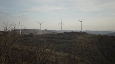 Dağdaki tarlada rüzgar türbinleri çalışıyor. Yenilenebilir enerji ve sürdürülebilirlik kavramı - Eko sistemleri
