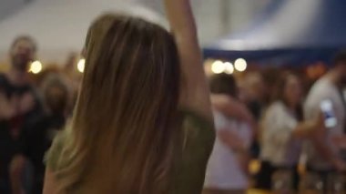 Geleneksel İspanyol partisinde heyecanlı atlayan genç sarışın kadın - 4K Yatay Video