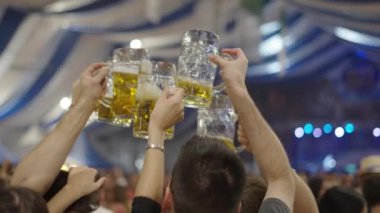 Kafkasyalı yetişkinler İspanya 'da bira bardaklarını kaldıran bir festivalde el ele verdi - 4K Yatay video
