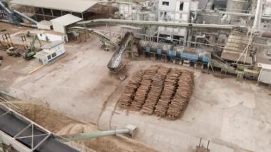 Kocaman bir kereste fabrikasının üzerinde uçan İHA 'nın ters görüntüsü. Bagajlar üst üste yığılmış ve talaş endüstrisi konsepti yığılmış.