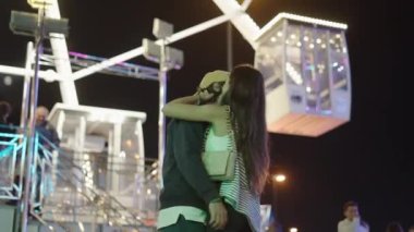 Dönme dolabın önünde birbirine gülümseyen ve birbirini seven çift - İspanyol Fuarı konsepti