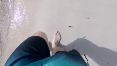 Yetişkin bir adamın mavi bir mayo giyip deniz kıyısında yürürken görüntüsü. - Paradisiac İspanyol mekanları