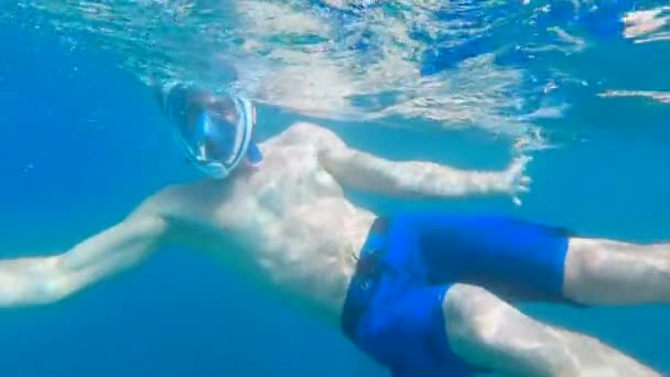Podwodny Widok Bliska Dopasowanego Mężczyzny Patrzącego Kamerę Unoszącego Się Morzu — Wideo stockowe