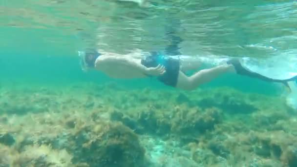 潜水マスクとフリッパー付きの浅いビーチで泳いでいる運動千年紀の少年の水中追跡ショット パラディアック スペイン語 — ストック動画
