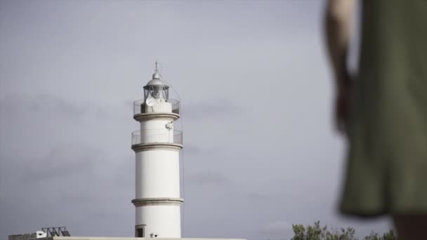 マヨルカ島の白い灯台に歩いて若い女性のスローモーションビュー パラディアック スペイン語 — ストック動画