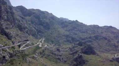 Bulutlu bir günde dağ yamacında yalnız ve eğimli bir rotanın havadan görüntüsü. - Paradisiac İspanyol mekanları
