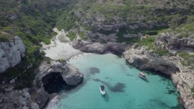 Kristal berrak su ve beyaz tekneleri olan bir körfezin üzerinden insansız hava aracı görüntüsü. - Paradisiac İspanyol mekanları