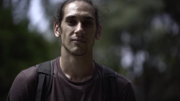 Genç Avrupalı Bir Adamın Ağaçlık Bir Alanda Kameraya Bakıp Gülümsemesi — Stok video