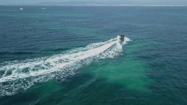 海に泡を残しジェットスキーを運転2人島観光 — ストック動画