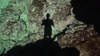 Mallorca Adası turizminin berrak sularında yetişkin bir erkeğin gölgesi.