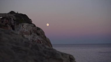Mallorca 'da günbatımı ve arka planda ay ile ada turizmi