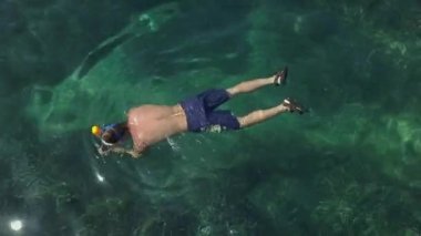 Beyaz adamlar Balear Adaları 'ndaki turizmde berrak suda şnorkelle yüzüyorlar.