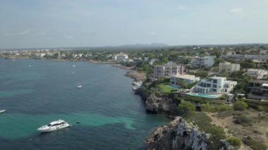 Çam ağaçları ve deniz kıyısı turizmi arasındaki lüks evlerin havadan görünüşü.
