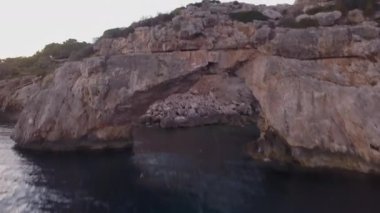 Kemerli bir kaya ve çam ağaçları ile dağlar arasındaki evler ada turizmi manzarası
