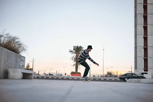 Běloch Pruhovaných Svetrech Tenisky Baví Skateboardu Městě Při Západu Slunce — Stock fotografie