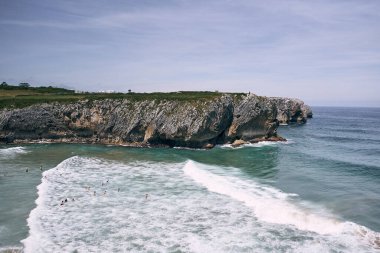 İnsanlar kayalık dağların ve kayalıkların, ribadesella asturias 'ın, İspanya' nın kuzeyinde şiddetli dalgalarda yüzüyorlar.