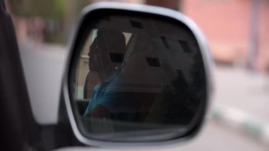 Taksisinde dikiz aynasındaki bir taksi şoförünün yansıması. Arap ülkesi.